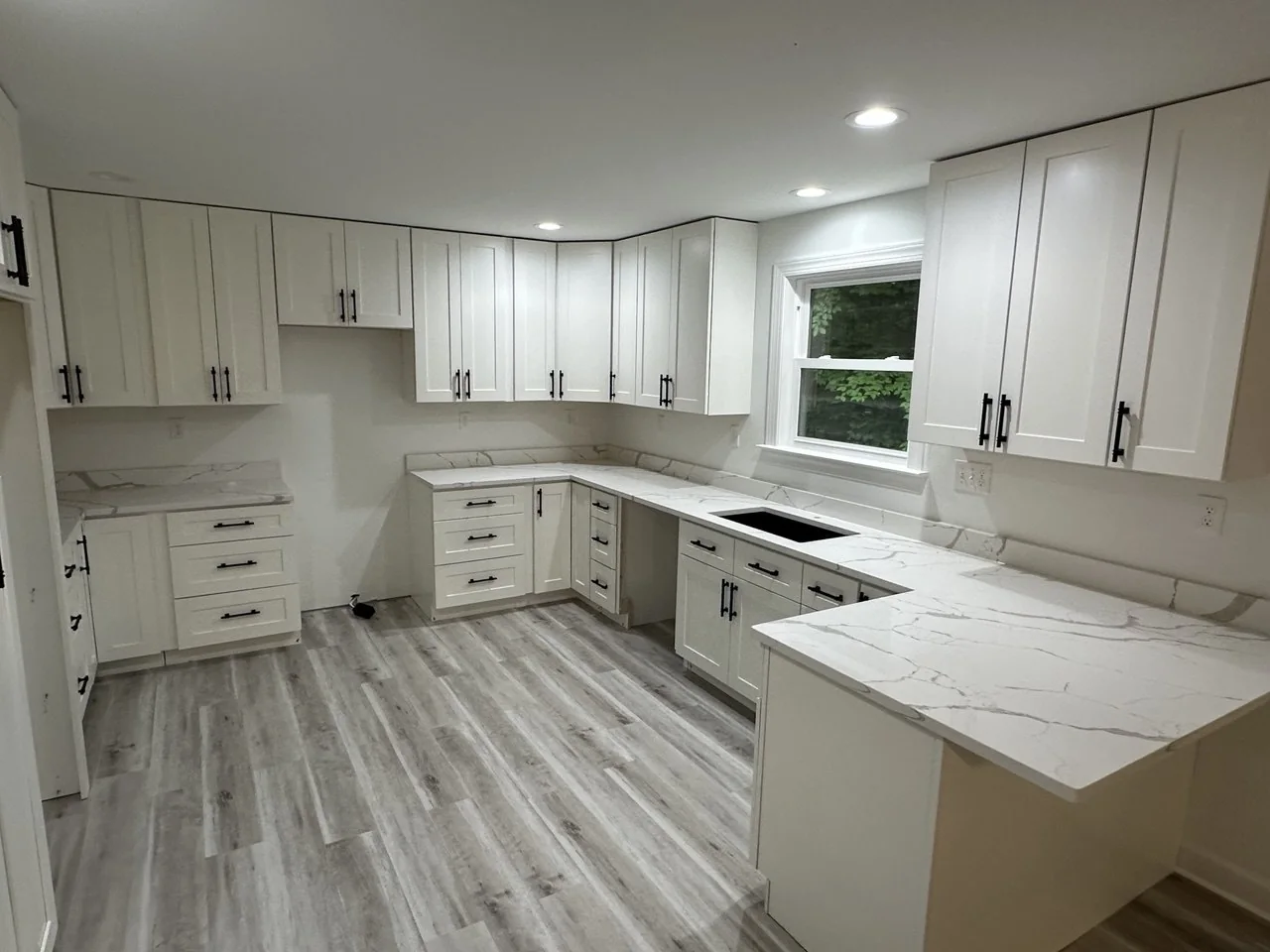 Bright U-shaped kitchen with marble-look counters